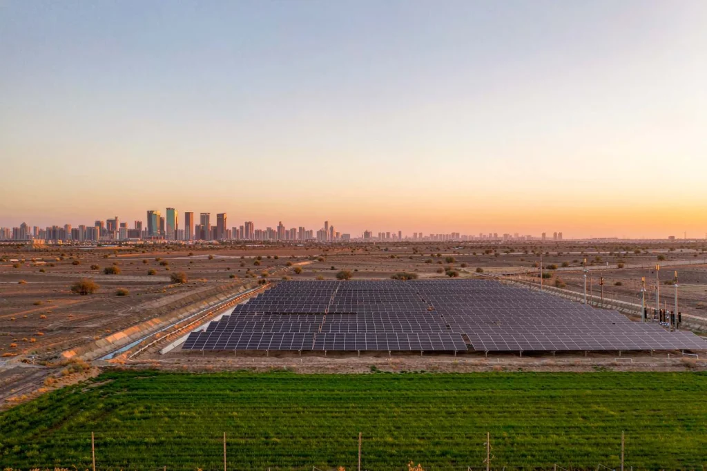 Solar array beside irrigated farmland in an arid Middle East landscape